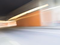 an abstract photo of a person riding down the street while a car is coming up and out