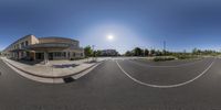 an 360 - degree view of street in front of a building near some bushes and a bench