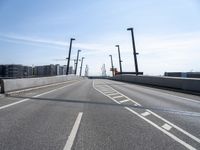 a street going under some tall poles and wires in the air on a clear day