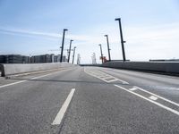 a street going under some tall poles and wires in the air on a clear day