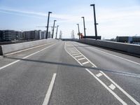 a street going under some tall poles and wires in the air on a clear day