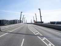 a street going under some tall poles and wires in the air on a clear day