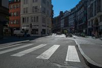 a street with several buildings on both sides and a motorcycle rider on the road behind it