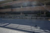 a brick wall with rocks on both sides of the street near the parking garages