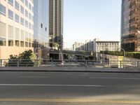 the view of a street where you can find a bus and cross a small bridge
