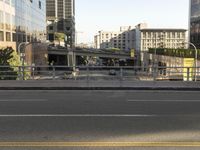 the view of a street where you can find a bus and cross a small bridge