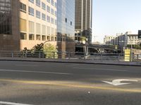 the view of a street where you can find a bus and cross a small bridge