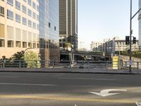 the view of a street where you can find a bus and cross a small bridge