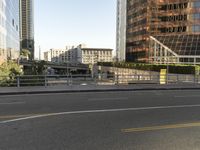 the view of a street where you can find a bus and cross a small bridge