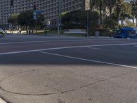 the car is driving near a stoplight and trees and buildings in a city street