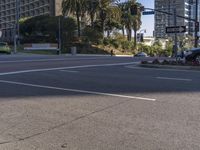 the car is driving near a stoplight and trees and buildings in a city street