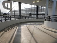 the ramp of a airport terminal has two benches and a view of the plane at the runway