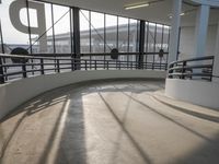 the ramp of a airport terminal has two benches and a view of the plane at the runway