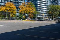 a bus stop sign in a parking lot near a tall building with trees and cars