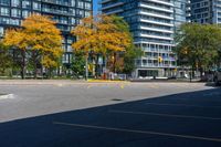 a bus stop sign in a parking lot near a tall building with trees and cars