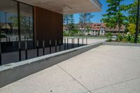 a skateboard rests on the wall near a park with trees in the background and an office