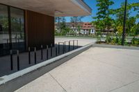 a skateboard rests on the wall near a park with trees in the background and an office