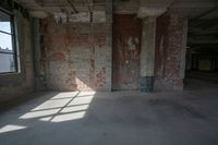 an empty loft with no windows near brick walls and windows in it, a few brick walls are in the way, a ceiling with exposed beams