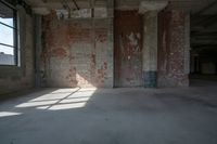 an empty loft with no windows near brick walls and windows in it, a few brick walls are in the way, a ceiling with exposed beams