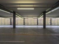 a large empty garage in front of a long wall filled with horizontal bars on top