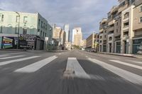 a view of an empty city street from the back seat of a car while driving in the city