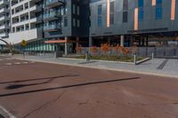 an empty street in front of a tall building with windows and a stop sign on each side