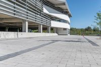 an empty concrete parking lot with trees, stairs and building in background in a public plaza