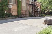 the steps leading to this building are next to a tree and a brick wall in the background