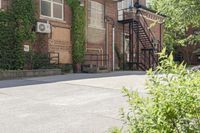 the steps leading to this building are next to a tree and a brick wall in the background