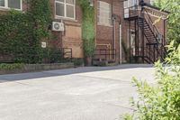 the steps leading to this building are next to a tree and a brick wall in the background