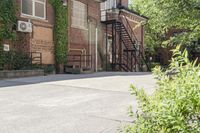 the steps leading to this building are next to a tree and a brick wall in the background