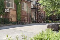 the steps leading to this building are next to a tree and a brick wall in the background