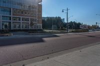 a street view with two buildings on either side of the road and a person walking in front of it