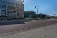 a street view with two buildings on either side of the road and a person walking in front of it