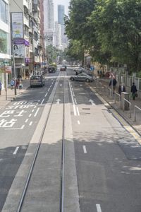 two trains running along the train tracks near a building and street with a bicycle in the distance