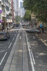 two trains running along the train tracks near a building and street with a bicycle in the distance
