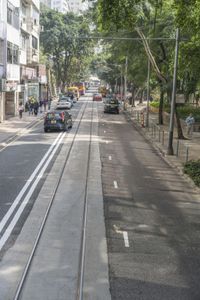 two trains running along the train tracks near a building and street with a bicycle in the distance