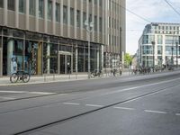 a city street with a large number of bikes on it and tall buildings behind the people