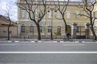 a person is crossing the street in front of an old building and cars on the street