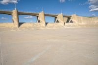 a concrete road with sand piles in front of it and some large pillars above it