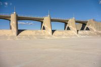 a concrete road with sand piles in front of it and some large pillars above it