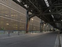 an empty street below an elevated bridge in an urban area of the city during the day