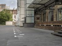 an empty building with signs on the street and people on bikes in traffic passing by