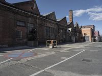 an empty road with the traffic gate open at the end of it and a building near by