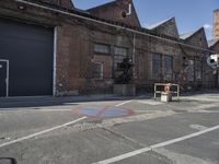 an empty road with the traffic gate open at the end of it and a building near by