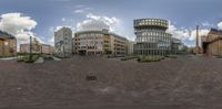 a fish eye lens image of a city square with buildings and streetlights around it