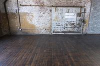 an old warehouse has a wooden floor and door in it, next to a brick wall and stairs