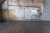 an old warehouse has a wooden floor and door in it, next to a brick wall and stairs