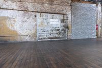 an old warehouse has a wooden floor and door in it, next to a brick wall and stairs