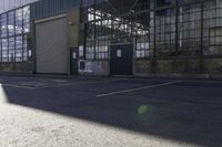 a lone white motorcyclist parked near the side of the street in an industrial area